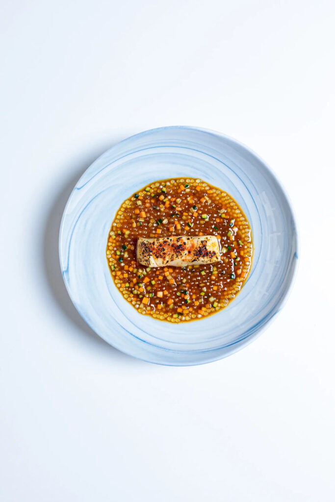 Filets de merlu nappés de beurre de saté sur lit de tapioca
