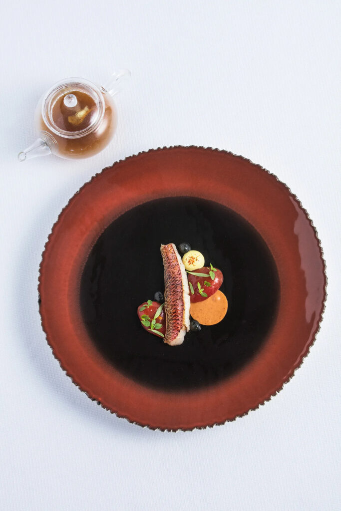 Rouget servi avec soupe de roche, rouille et garnitures