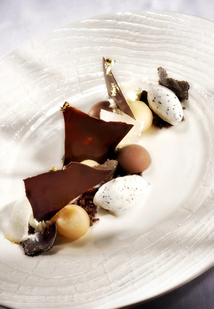 Poire pochée servie avec crémeux chocolat, sable cacao et glace à la truffe