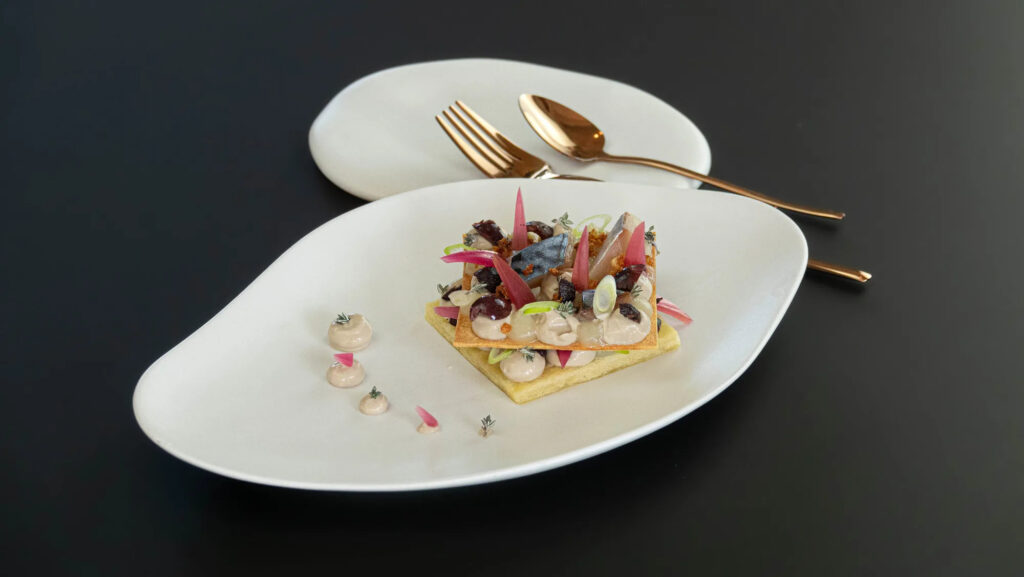 Pissaladière garnie d’oignons, anchoïade, lisette gravlax et olives
