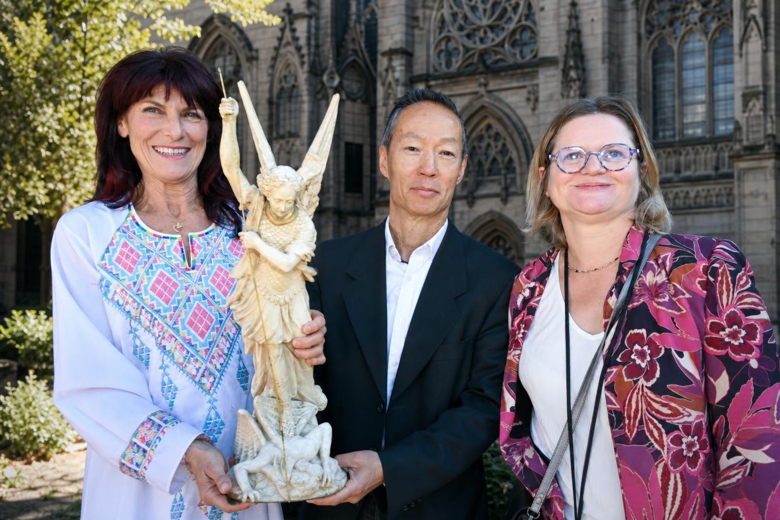 Mains de chef posant une petite statue de Saint-Michel sur une étagère en bois, arrière-plan de cuisine professionnelle flou